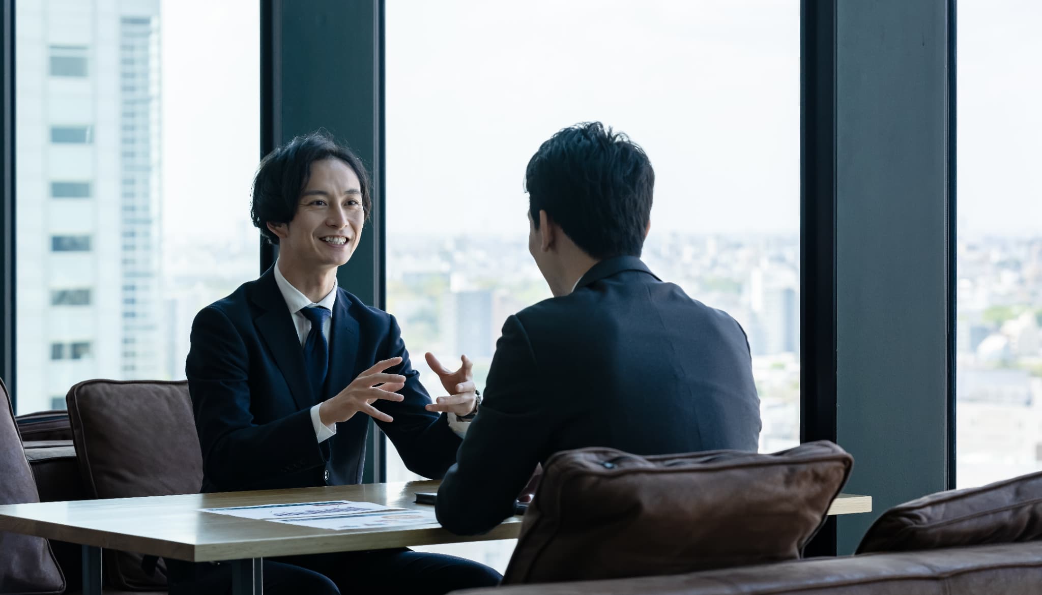 向かい合って対談している男性2人